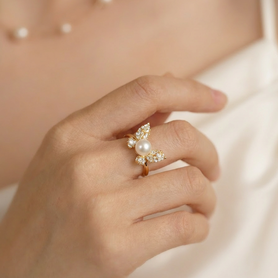 Hand wearing a decorative ring with pearls on a soft background